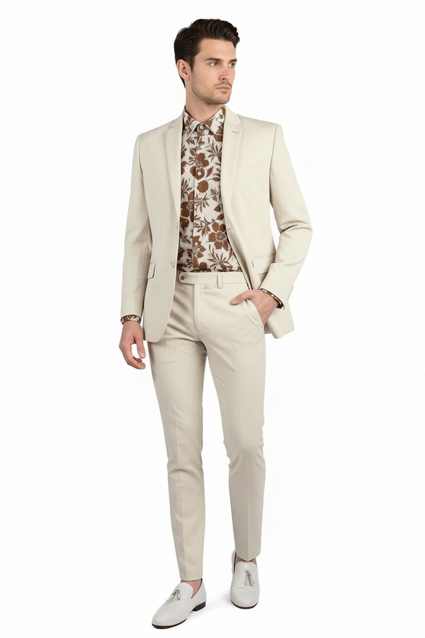 Man wearing a beige suit with a patterned shirt on a white background